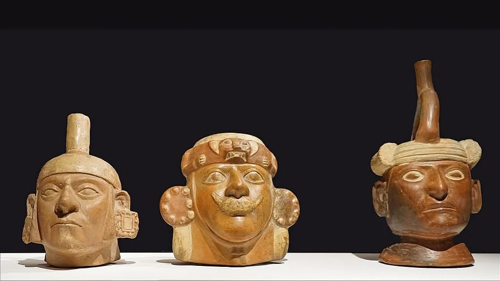 Three Moche ceramic portrait vessels with distinct facial features and headdresses.