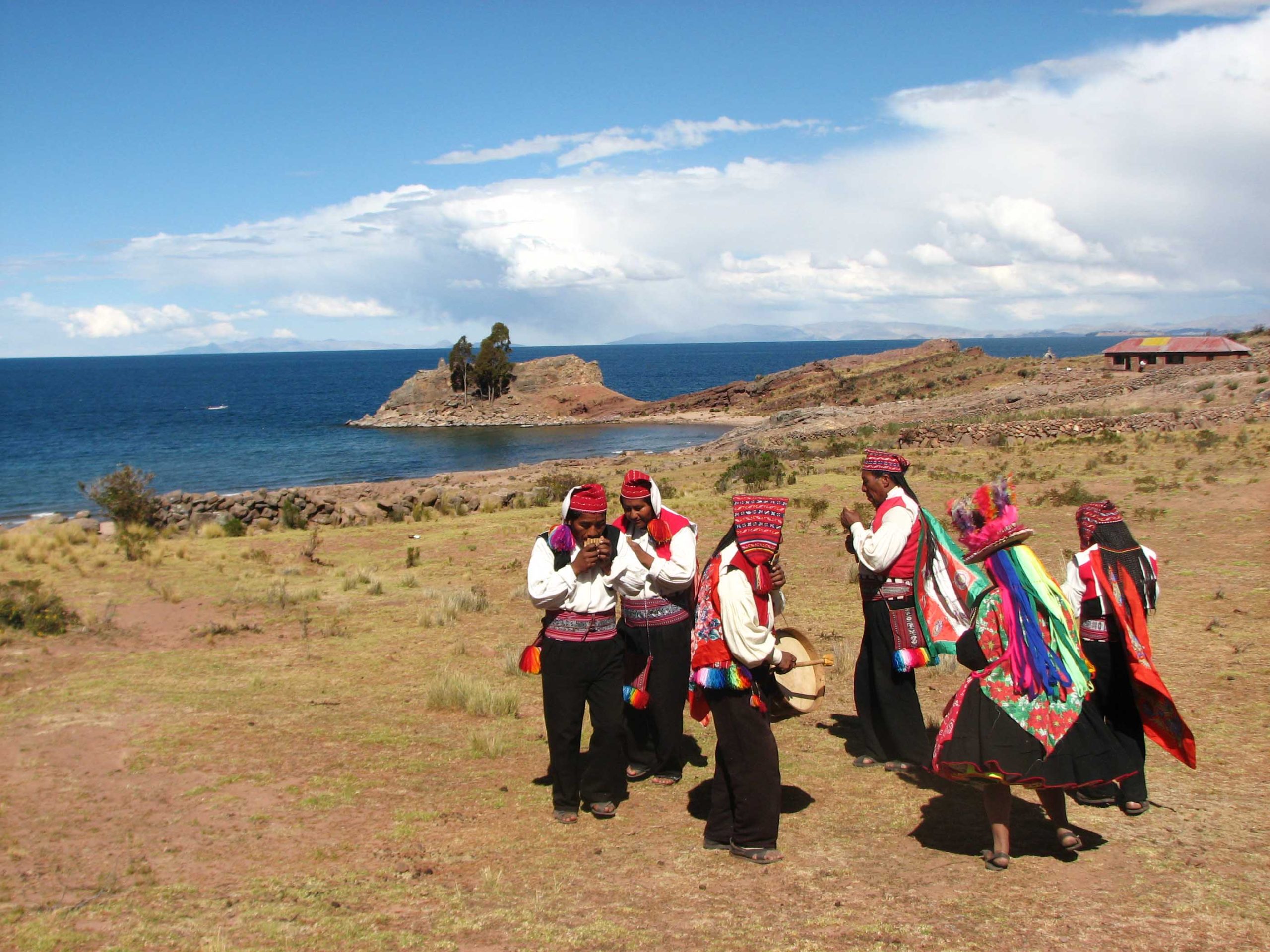 Traditional dancers performing near Lake Titicaca in colorful costumes.