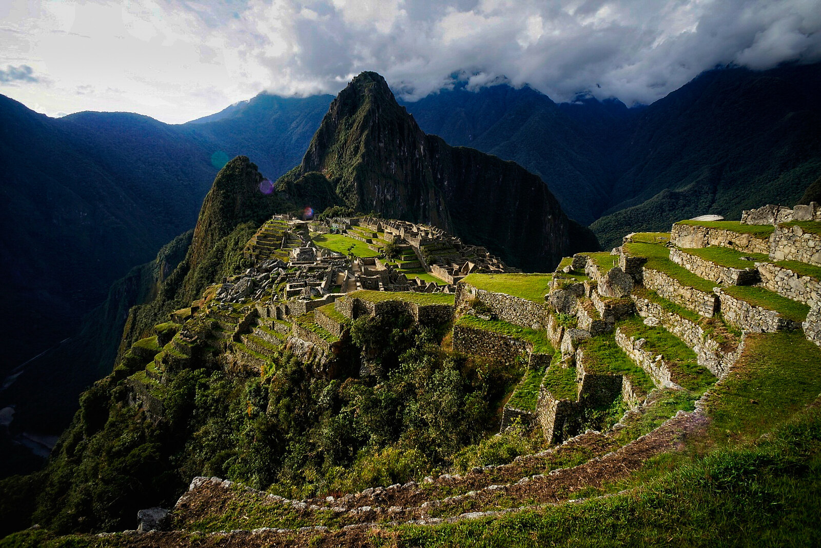 View of Machu Picchu ruins with surrounding mountains.