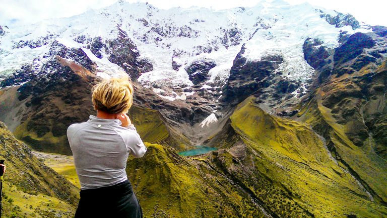 Hikers trekking the Salkantay Trail with towering snow-capped peaks.